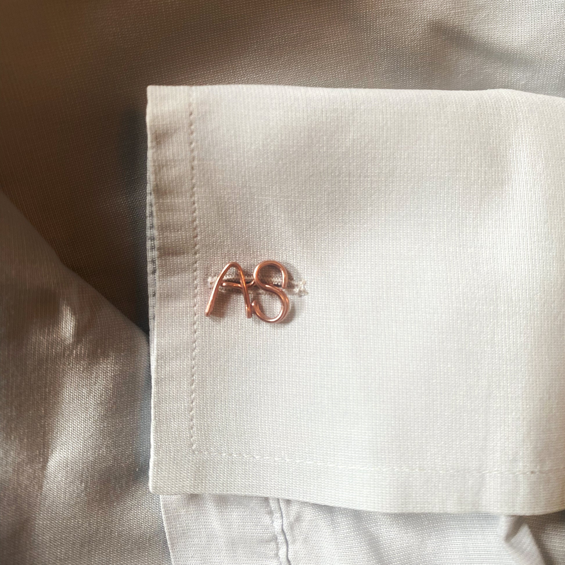 gemelli personalizzati con iniziali realizzati in oro giallo e indossati su una camicia bianca