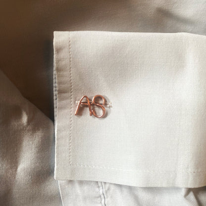 gemelli personalizzati con iniziali realizzati in oro giallo e indossati su una camicia bianca